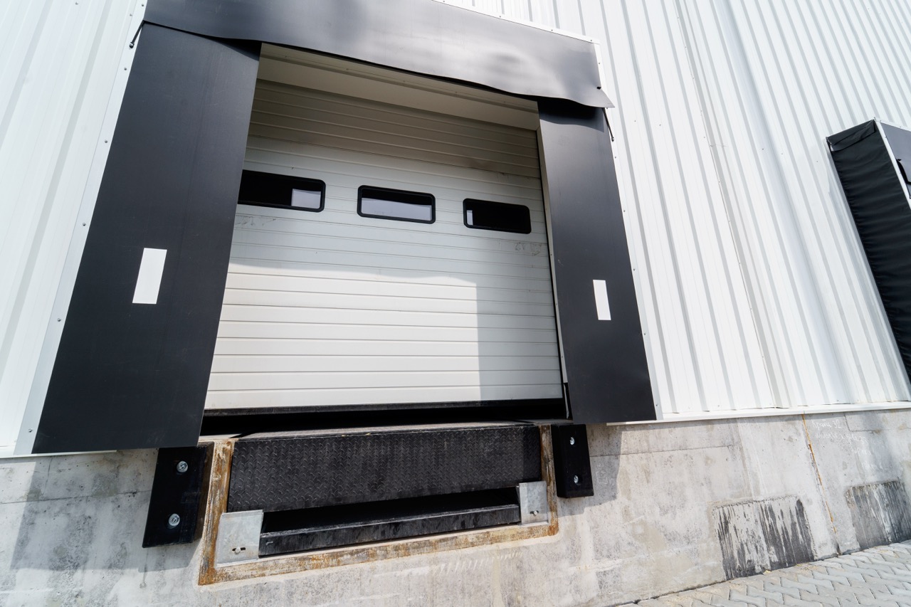 Warehouse gate for loading and unloading cargo in a distributed center Sectional warehouse gate for loading and unloading cargo in a distributed center. Loading and unloading areas for trucks. Construction of an industrial building